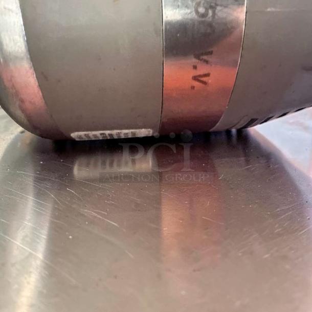 Close-up of Robot Coupe MP450VV immersion blender end, showing variable speed label. Blender is heavy-duty and fully operational.