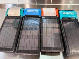 Set of 4 Sunmi V2 wireless POS terminals, built-in receipt printers, excellent condition, labels indicate various delivery services.