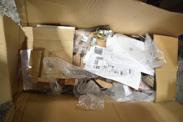 Cardboard box containing parts, manuals, and packaging materials for Rational iCombi Pro ovens, ready for assembly.