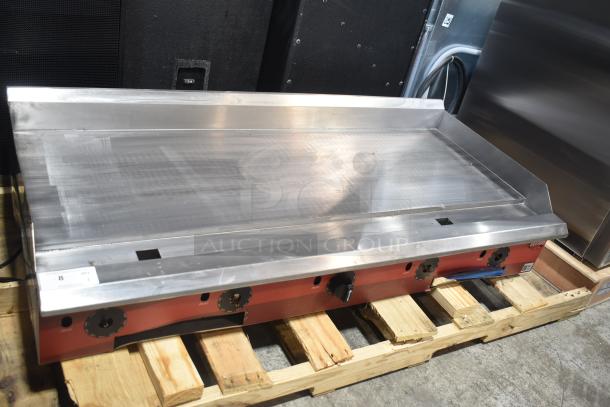 Brand new Avantco 177CAG60MG commercial gas flat top griddle with minor scratches, on wooden pallet in warehouse setting.