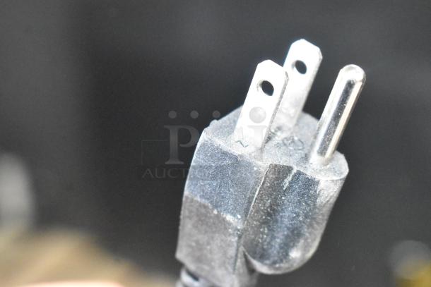 Close-up of a power plug from the Avantco 194MCF530A ice machine, showing prongs and a slightly dusty surface.