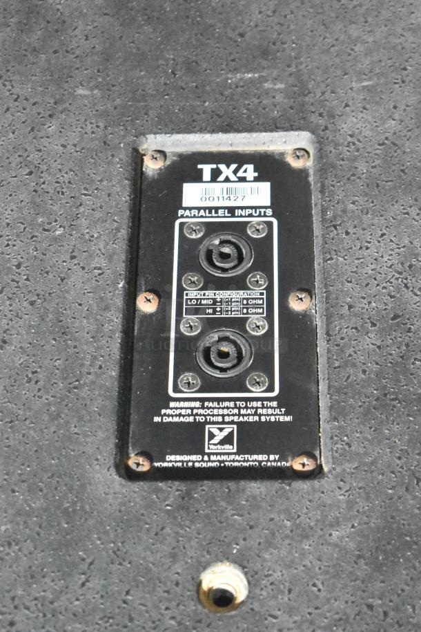 Yorkville TX4 speaker close-up, showing parallel inputs panel with input pin configuration and warning label.
