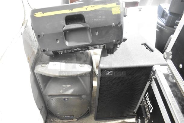 Three speakers for auction: Behringer Eurolive B212A, Mackie C300, Yorkville TX4; visible wear, ideal for sound enthusiasts.