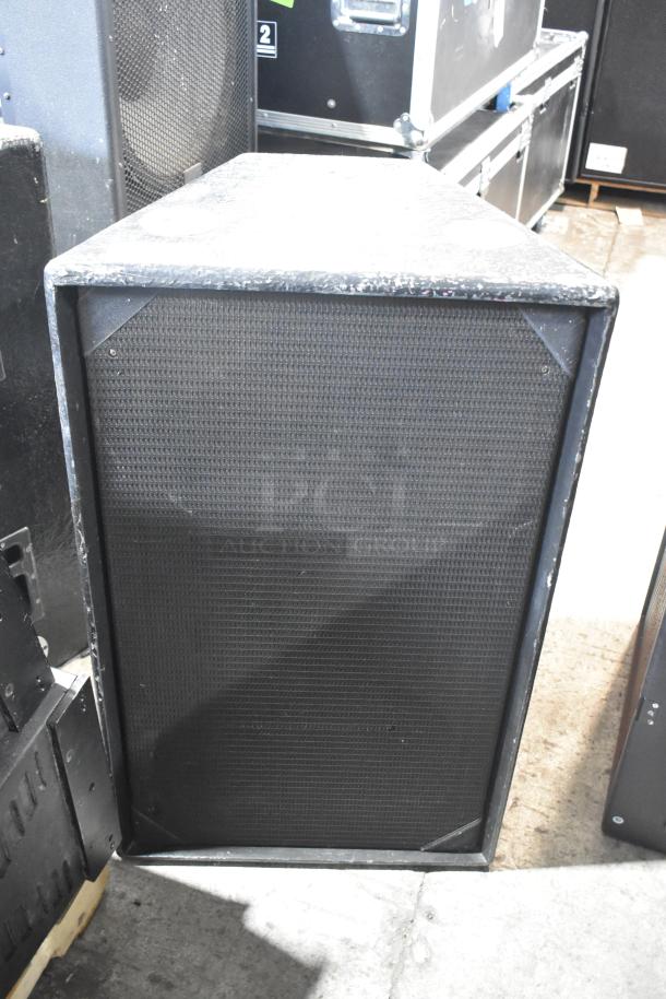 Large black speaker with a textured front grille and visible wear on the edges, in used condition. Auction includes two units.