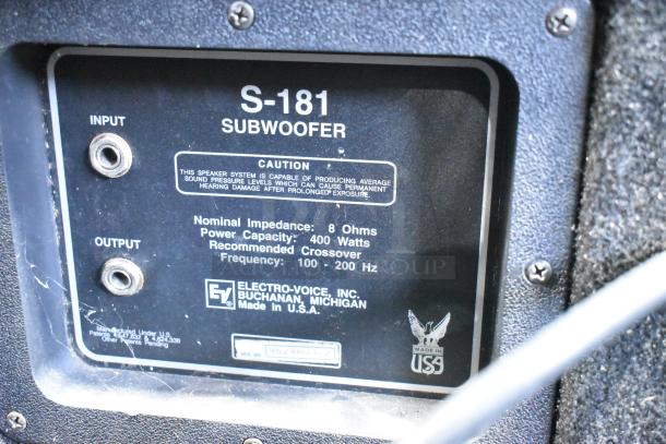 Close-up of a label on a subwoofer, showing details like input/output ports, nominal impedance of 8 Ohms, 400-watt power capacity, and a frequency range of 100-200 Hz. Made by Electro-Voice, Inc., USA.