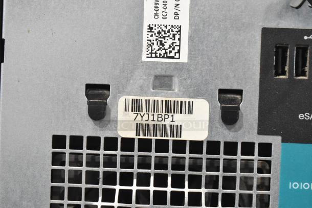 Dell computer tower showing ventilation grid and USB ports. Barcode with code "7YJ1BP1" and QR code visible.
