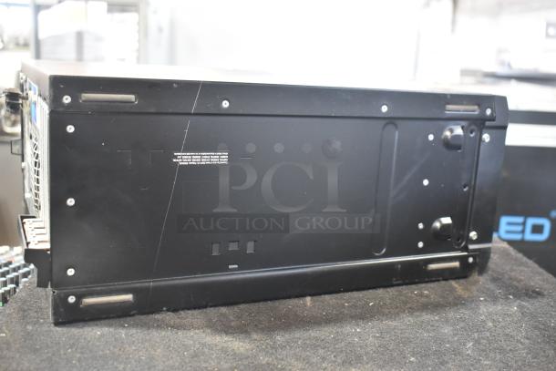 Dell computer tower, black, showing rear panel with multiple ports. Some surface scratches visible.