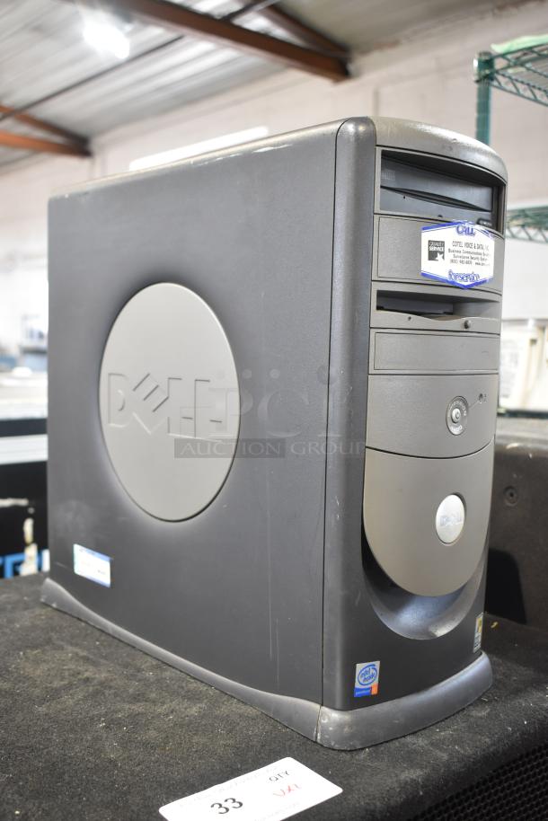 Dell computer tower in used condition with visible Dell logo and manufacturer's label. Features multiple drive bays.