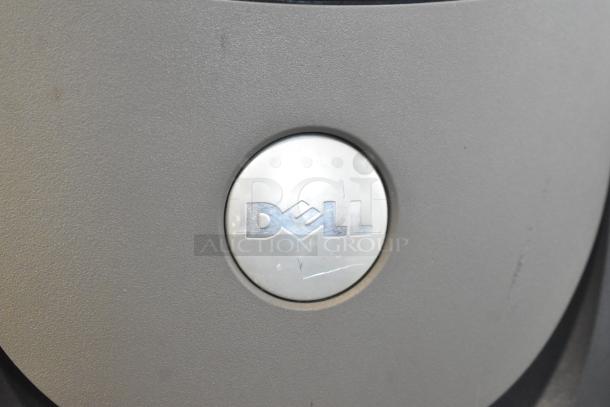 Dell computer tower close-up, featuring the Dell logo on a metallic surface.