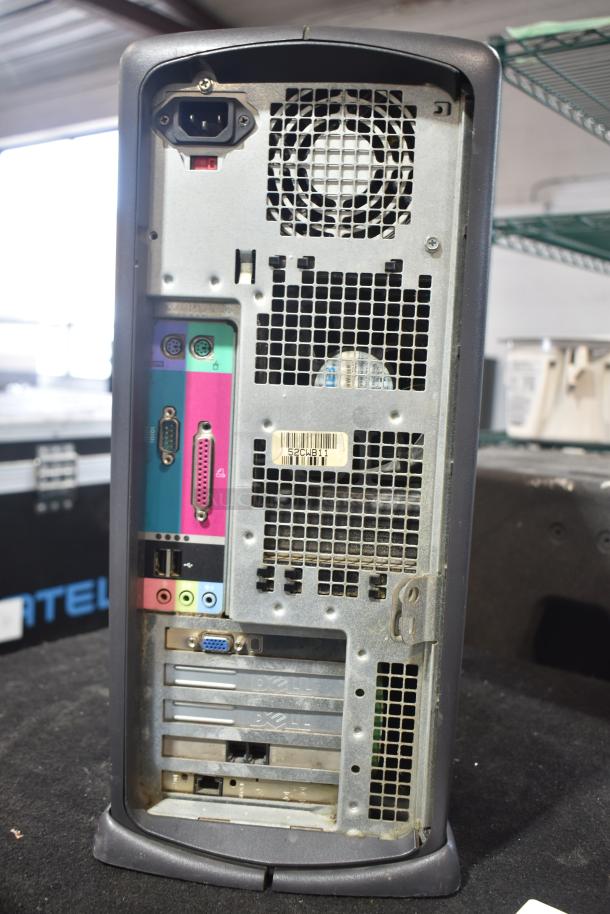 Dell computer tower showing rear ports and ventilation, moderate wear, visible Dell branding and model number tag.