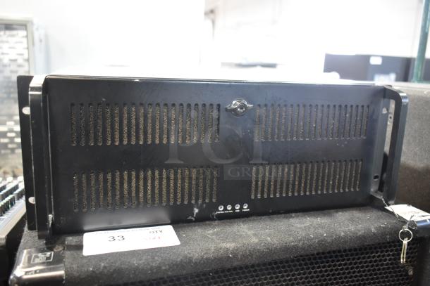 LG Rack Unit with a black metal casing featuring ventilation slots. Equipped with indicator lights for system, fan, and power status. Overall condition appears used.