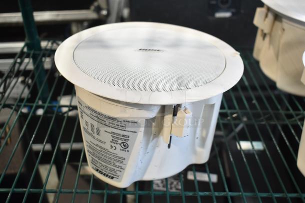 4 Bose FreeSpace DS 16F loudspeakers, ceiling-mounted, white, with labels detailing specifications, lightly used condition.