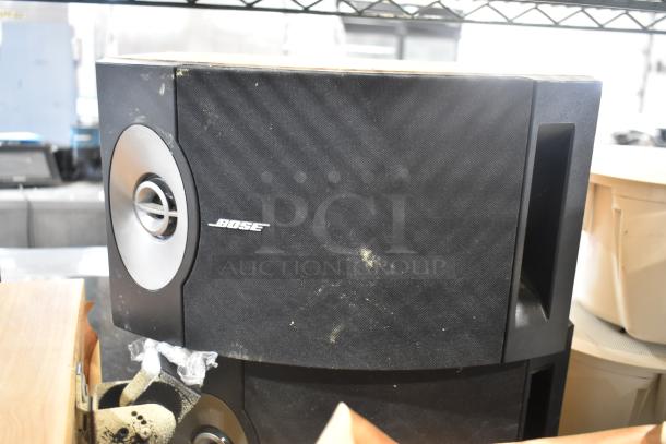 5 speakers including one Bose 201 V speaker, black casing, visible wear, renowned for clear audio quality.