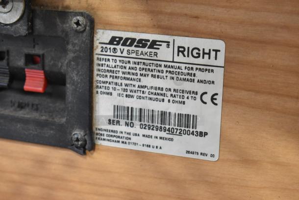 Bose 201 V speaker label showing model, serial number, and compatibility information on a wooden background.