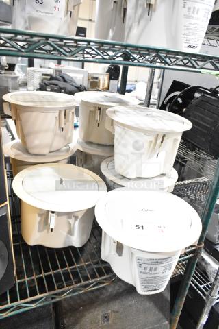 Four Bose FreeSpace DS 16F Loudspeakers on a shelf, featuring white casing and Bose branding.