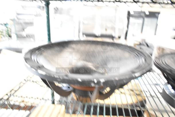 Blurred image of a speaker on a shelf, likely the Faital Pro 12HP1030 or Yorkville NX750P, condition unclear.