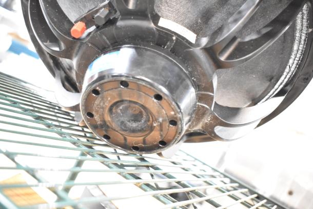 Faital Pro 12HP1030 speaker, black finish, 8 ohm, detailed close-up showing back view on metal rack.