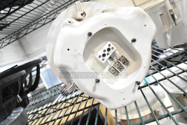 Three Bose FreeSpace DS 16F loudspeakers, white, ceiling mount, new condition, wires and connectors visible, on a shelf.