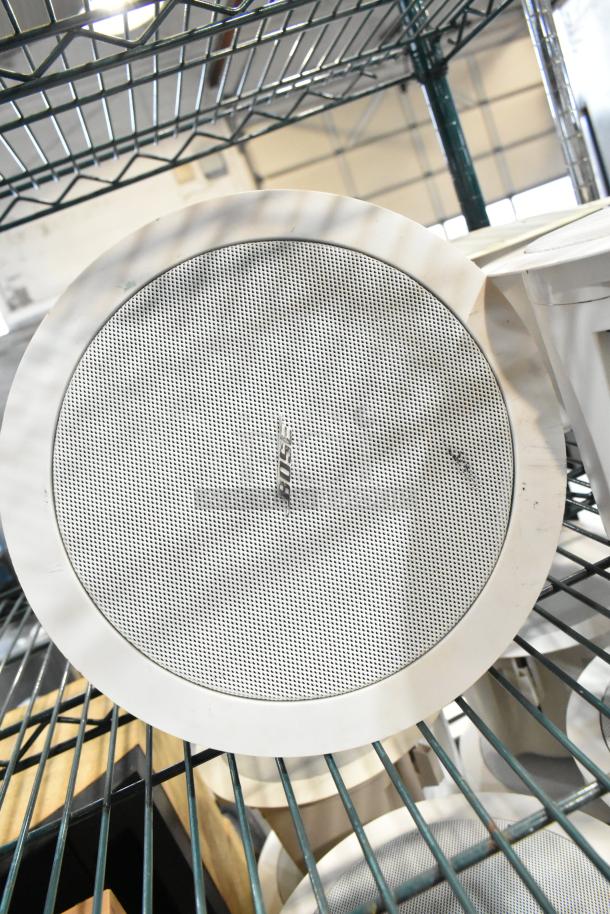 Alt text: Three Bose FreeSpace DS 16F loudspeakers, ceiling-mounted, white grille, minor wear, auction set, shelf display.