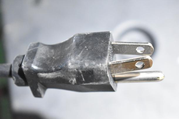 Close-up of a power plug from an electronic device included in auction lot with Xantech video switcher and Altronix power supplies.