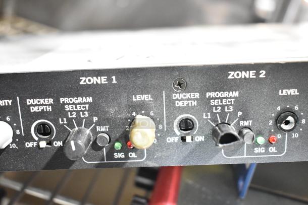 Close-up of Rane CP 64S Commercial Processor controls for zones 1 and 2, showing dials and switches for program select and level.