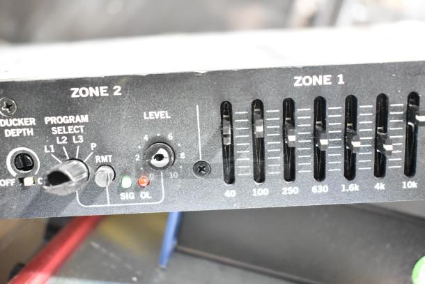 Close-up of a Rane CP 64S Commercial Processor featuring Zone 1 and Zone 2 controls, program select, and level adjustments.