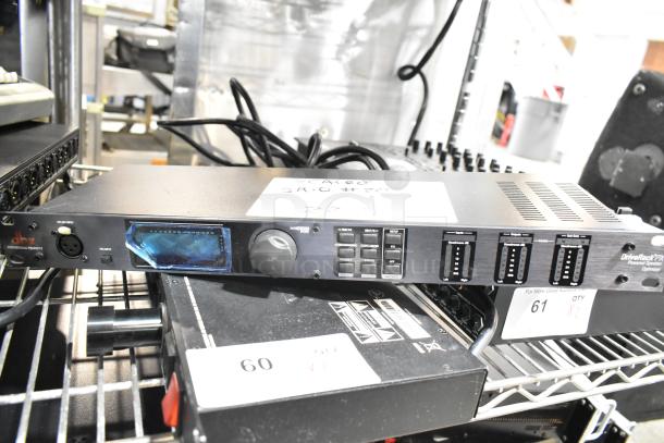 3 audio devices including Shure PG4, DBX DriveRack PX, and Samson PowerBrite Pro15, on metal shelving, labeled.