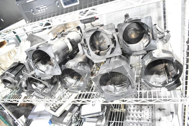 9 GoboSource ES-B10E stage lights on a shelf. Black casing, slight wear. Auction includes 9 units, enhancing value.