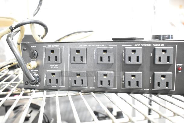 Panamax M5100-PM power conditioner with multiple outlets, 15 AMP circuit breaker, and labeled banks for various devices.