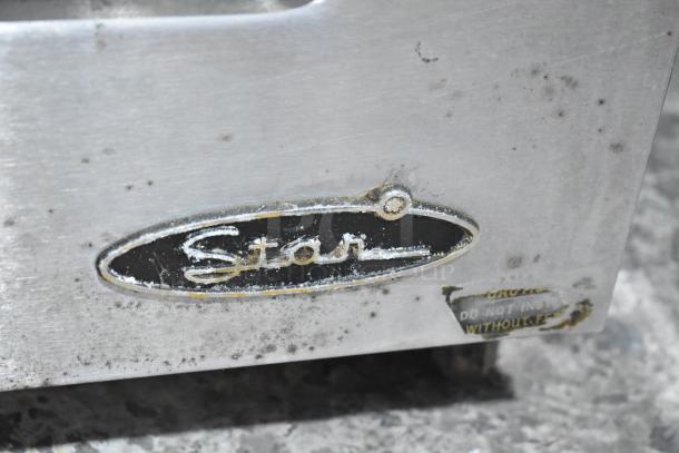 Star commercial electric griddle with dual side grease trays, stainless steel surface, visible wear, logo and caution label.