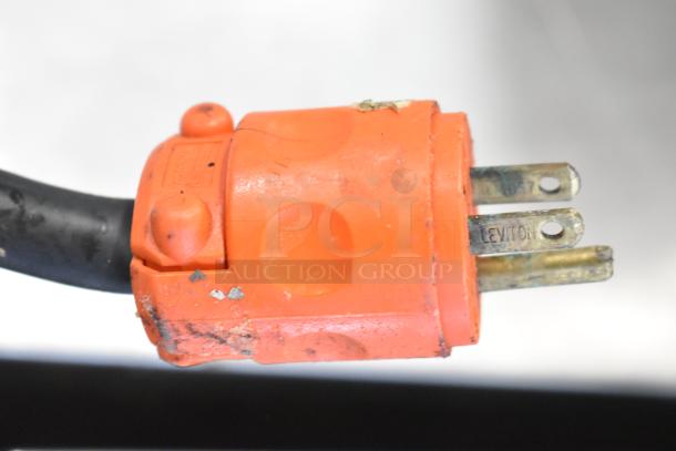 Close-up of a worn orange power plug attached to a cable marked "Leviton." Visible wear and grime on the surface.