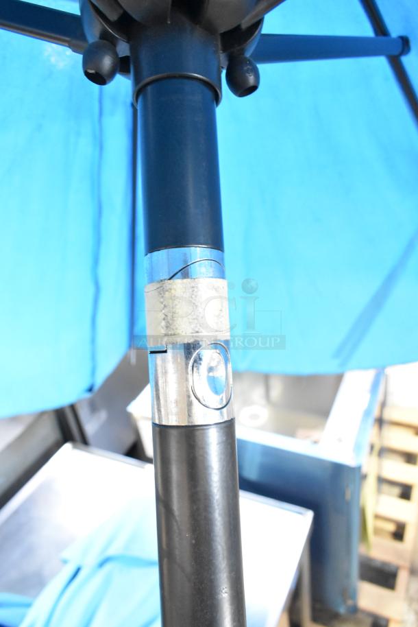 Two blue patio umbrellas with metal poles, in good condition, featuring a crank handle for easy opening and closing.