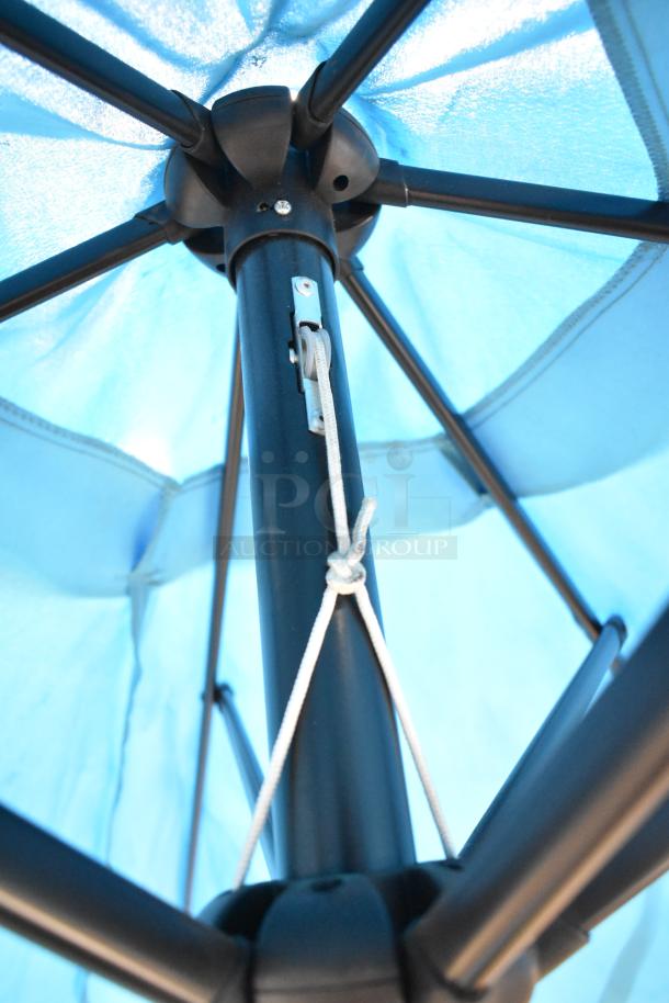 Two blue patio umbrellas with sturdy frame, seen from underneath. Smooth mechanism with rope tie. New condition.