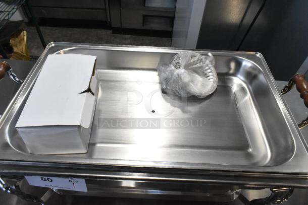 "Brand new scratch and dent countertop chafer with metal handles, includes box and wrapped accessory inside."