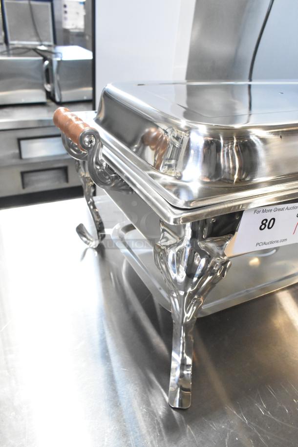 BRAND NEW SCRATCH AND DENT countertop chafer with ornate legs, wooden handles, slight imperfections, auction tag visible.