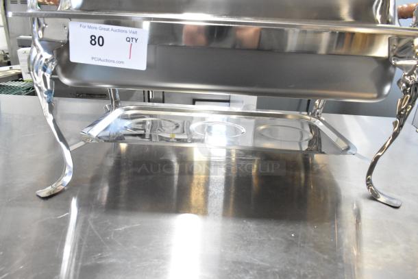 BRAND NEW SCRATCH AND DENT stainless steel countertop chafer with ornate legs, minor blemishes visible, includes auction tag.