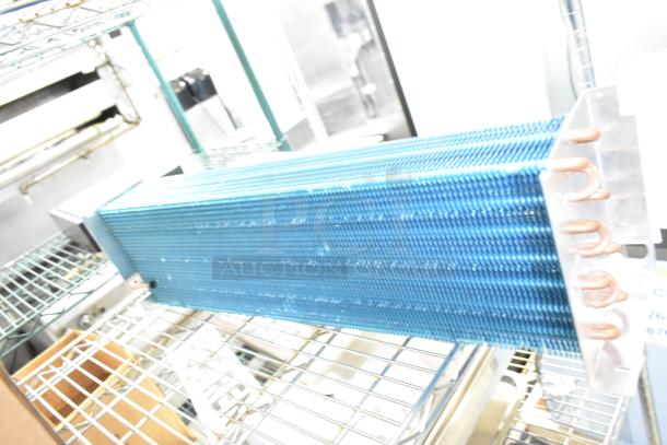 Brand new evaporator coil, model 17404070621, 17812873HC. Minor scratches and dents visible. Blue fins, copper tubing.