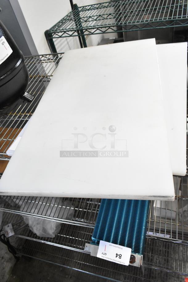 2 new white cutting boards, Choice 40724185WH, 24"x18"x1/2" polyethylene, minor scratches, shown on metal rack.