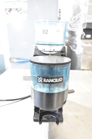 Rancilio Rocky Doser espresso bean grinder, no lid, 110V. Black body, clear hopper, branded logo. Good condition.
