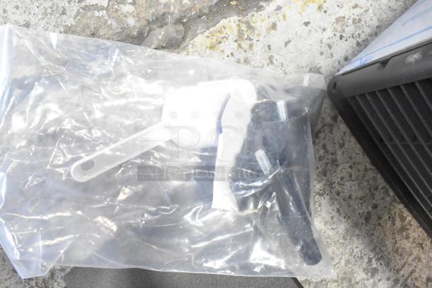 Plastic bag with white scoop and accessories for Manitowoc UDP0065A-161 ice machine, visible on concrete background. 