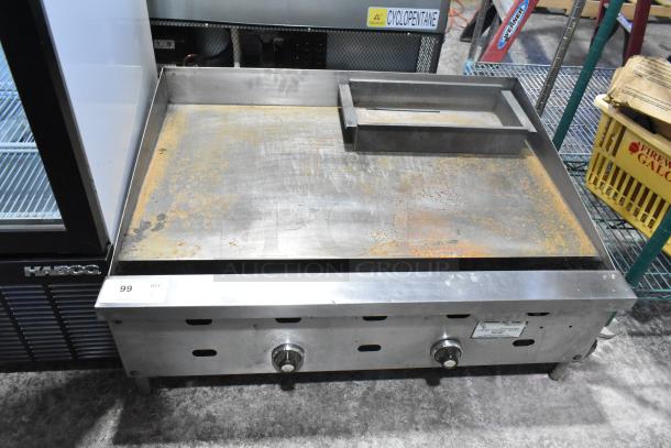 US Range Commercial Gas Flat Top Griddle; features rust on surface, dual knobs; ideal for professional kitchens.