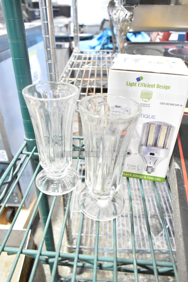 Two clear glass vases on a shelf, next to a box labeled "Light Efficient Design LED-8038E345-A."