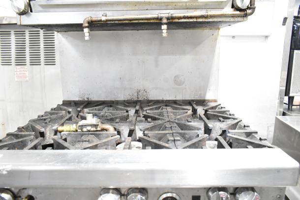 Southbend commercial 6-burner range with oven, cheese melter, and backsplash. Natural gas, moderate wear evident.