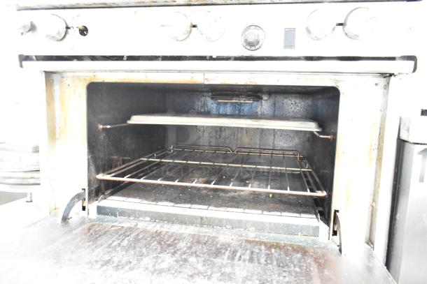 Southbend commercial gas 6-burner range with oven, cheese melter, and backsplash. Used condition, visible wear.