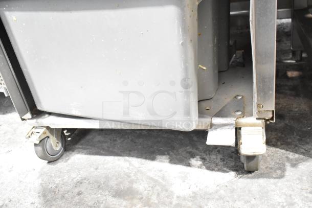 Commercial JBT 2ND-GEN-MFJ-HE citrus juicer on casters, floor style. 115V, 1 phase. Visible wear, ideal for commercial use.