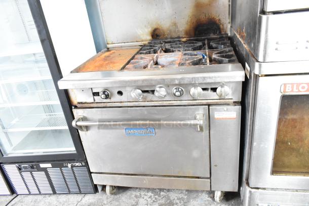Imperial commercial gas-powered 4-burner range with flat top griddle, oven, over shelf, and back splash on casters. Used condition.