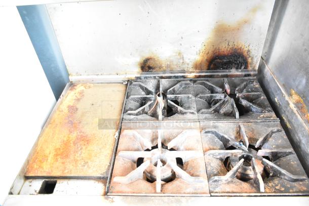 Imperial commercial gas range with 4 burners, flat top griddle, oven, over shelf, and backsplash on casters; used condition.