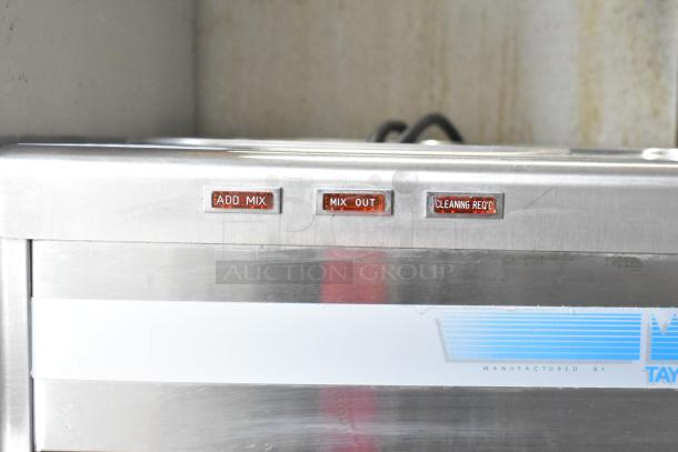 Taylor commercial floor 2-flavor frozen beverage machine with add mix, mix out, and cleaning req'd indicators.