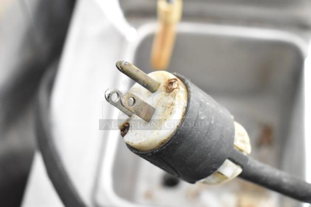 Taylor frozen beverage machine plug, showing signs of use. Model supports 115 volts, 1 phase.
