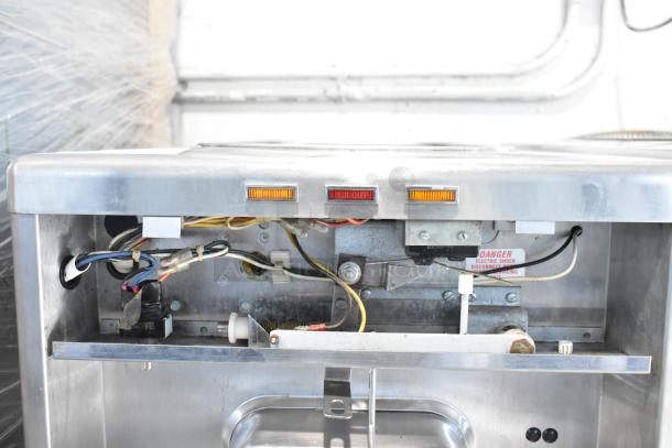 Taylor commercial countertop single flavor frozen beverage machine, exposed internal wiring, stainless steel.